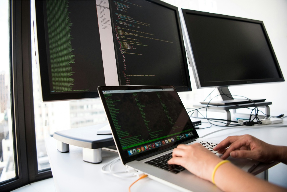 Persona programando con varias pantallas